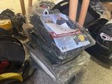 une pile de bagages posée par terre à côté d'une pile d'autres objets