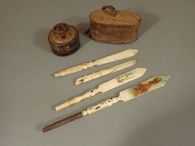 quatre types de couteaux différents et une boîte posée sur la table