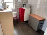 a small kitchen with a refrigerator, microwave, and a sink