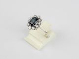 a black and white diamond ring on a white marble stand