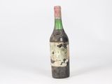 an old bottle of wine sitting on top of a white surface