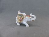 une petite figurine représentant un éléphant posée sur une surface grise