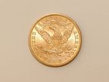 a close up of a gold coin on a white surface