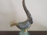 une sculpture en verre représentant un oiseau posé sur une table