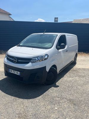une camionnette blanche garée devant un mur bleu