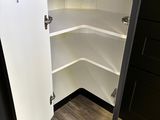 an image of a corner kitchen cabinet with a door open