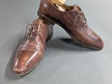 a pair of brown shoes sitting on top of a gray surface