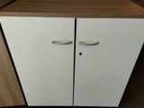 a white cabinet with two doors and a wooden top