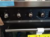 a close up of a black oven with a yellow tag on it