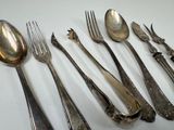 a lot of silver spoons and forks on the table