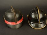 two helmets that are sitting side by side on a black surface