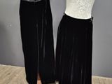 two mannequins in black and white dresses on display in front of a gray wall