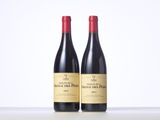 two bottles of red wine sitting on top of a table