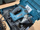 a blue tool in a blue box on a wooden floor