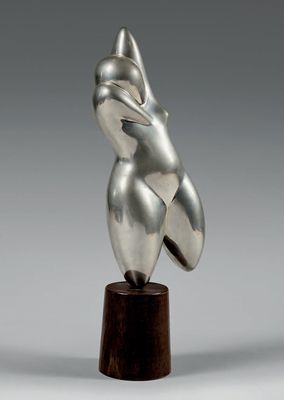 une sculpture en argent représentant une tête de femme posée sur un socle en bois