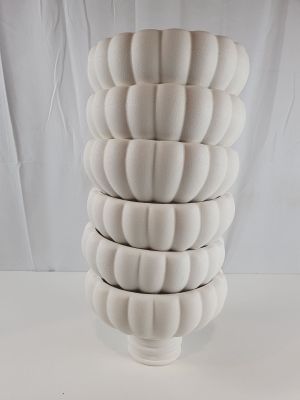 plusieurs vases blancs empilés les uns sur les autres sur une table
