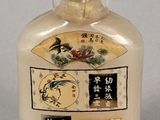 a small glass bottle with asian writing on it
