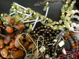 a lot of beads and necklaces that are on a table