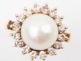 a close up of a pearl and diamond ring on a white background