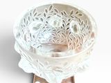 a white glass bowl with a flower design on it