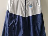 a white and blue windbreaker jacket hanging on a wall