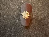 a ring with a flower on it sitting on the ground