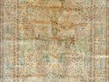 an antique persian rug with a floral design on a beige ground
