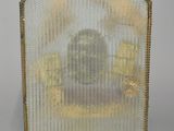 an antique brass fireplace screen with a picture of a man in a chair
