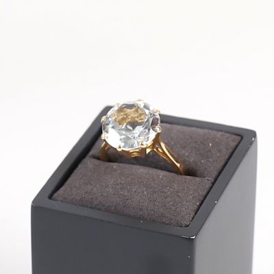 une bague en diamant dans un écrin noir posé sur une surface blanche