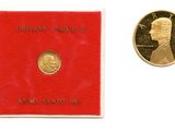 un gros plan d'une pièce de monnaie et d'une enveloppe rouge posées sur une surface blanche