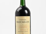bottle of red wine with a wooden stopper on a white surface