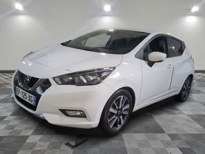 la voiture blanche est garée sur un sol en damier dans le garage