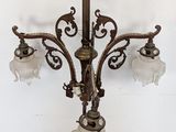 an antique brass chandelier with frosted glass shades hanging from the ceiling