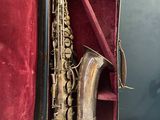 an old saxophone in a red case on a table