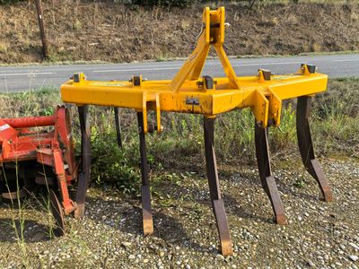 a yellow plow sitting on the side of the road