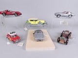 five different model cars on display in a display case