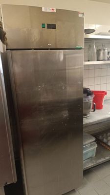 a stainless steel refrigerator in the middle of a kitchen