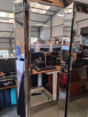 un grand miroir au milieu d'une pièce remplie de matériel informatique