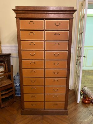 a tall wooden cabinet with many drawers in it