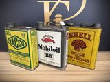 three cans of oil sitting on a table next to each other