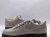 the nike air force 1 low is a light grey sued shoe with black soles