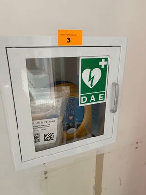 un extincteur encastré dans le mur, à côté d'une borne d'incendie