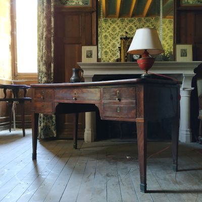 un bureau sur lequel est posée une lampe, dans une pièce