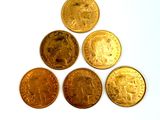 six different types of gold coins on a white surface