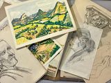 a pile of drawings on a table next to a laptop