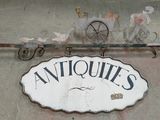 une enseigne indiquant « antiquités » sur la façade d'un immeuble