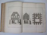 an open book with a drawing of a building and a picture of a house