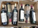 several bottles of wine are in a cardboard box on the floor