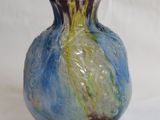 a blue and yellow vase sitting on a white surface