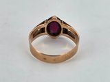 a close up of a gold ring with a purple stone